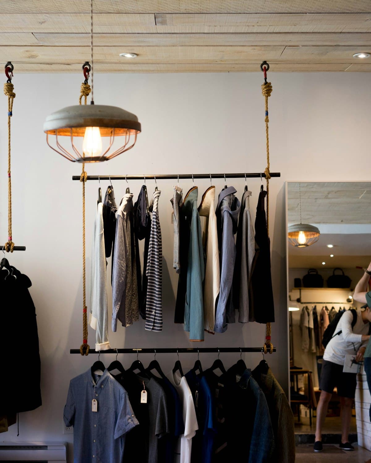 Intérieur d'une boutique de prêt-à-porter avec portants et éclairage soigné